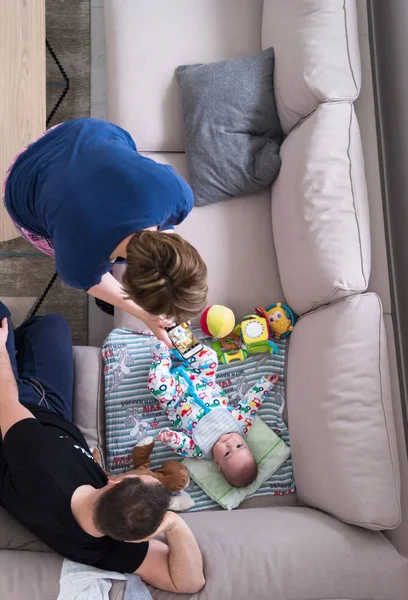 Vista dall'alto di madre e padre felici che fotografano il bambino — Foto Stock