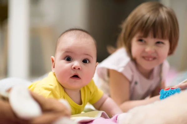 Zusje en haar baby broer spelen thuis — Stockfoto