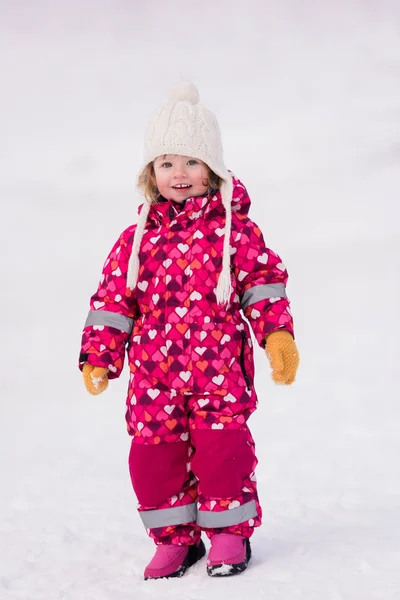 Karlı kış gününde eğlenen küçük kız — Stok fotoğraf