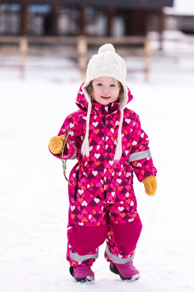 Karlı kış gününde eğlenen küçük kız — Stok fotoğraf