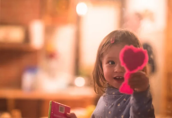 Malá roztomilá dívka, co si hraje u okna — Stock fotografie