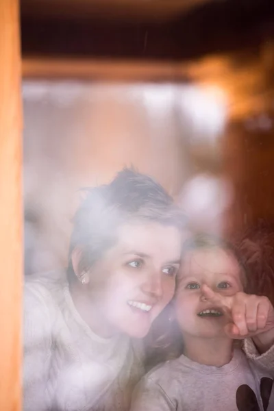 Young mother and little cute daughter playing near the window — Stock Photo, Image