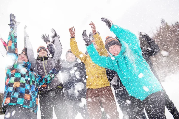 Group of young people throwing snow in the air — Stock Photo, Image