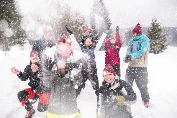 Grupa młodych ludzi rzucających śnieg w powietrze — Zdjęcie stockowe