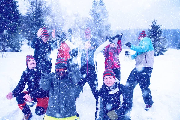 Grupo de jovens jogando neve no ar — Fotografia de Stock