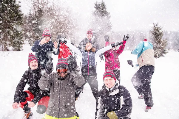 Groupe de jeunes jetant de la neige dans les airs — Photo