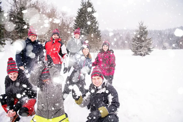 Groep jongeren die sneeuw in de lucht gooien — Stockfoto