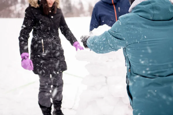 Grupo de jóvenes haciendo un muñeco de nieve — Foto de Stock