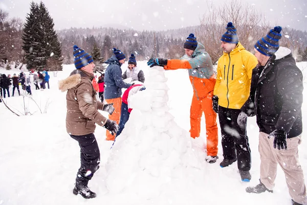 Gruppo di giovani che fanno un pupazzo di neve — Foto Stock