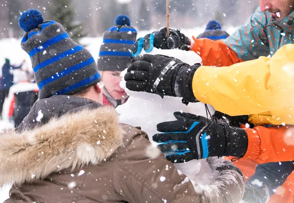 Gruppe junger Leute bastelt einen Schneemann — Stockfoto