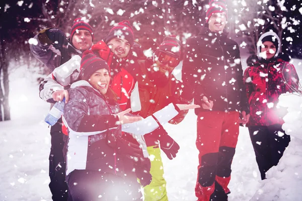 Gruppenporträt junger Leute, die mit Schneemann posieren — Stockfoto