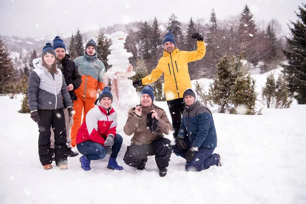Ομάδα portait των νέων που ποζάρουν με χιονάνθρωπο — Φωτογραφία Αρχείου