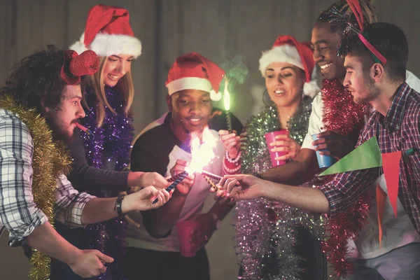 Multiethnic group of casual business people lighting a sparkler — Stock Photo, Image