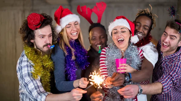 Multiethnic group of casual business people lighting a sparkler — Stock Photo, Image