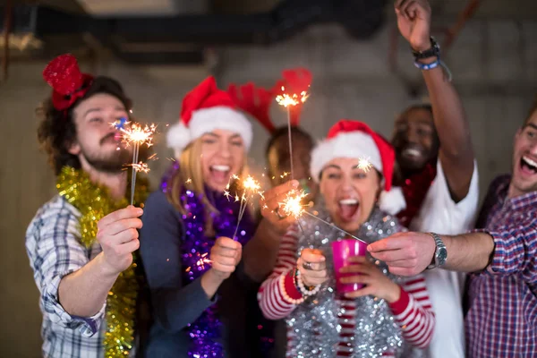 Multiethnic group of casual business people lighting a sparkler — Stock Photo, Image