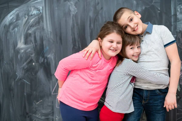 Группа детей, обнимающихся перед доской — стоковое фото