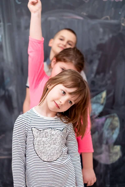 Group of kids standing in front of chalkboard — Stock Photo, Image