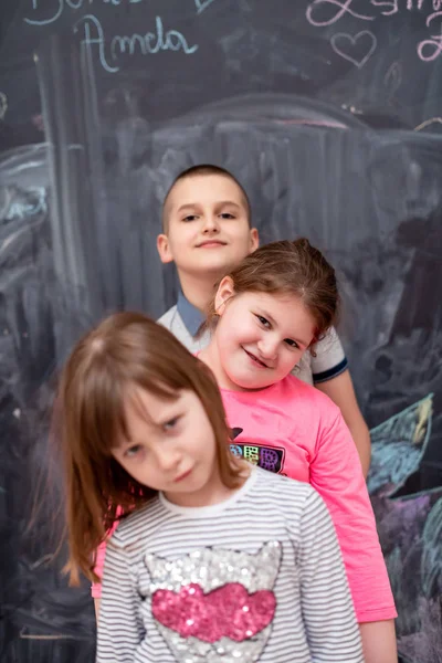 Groupe d'enfants debout devant le tableau — Photo