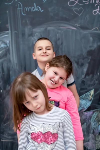 Grupo de niños de pie frente a la pizarra — Foto de Stock