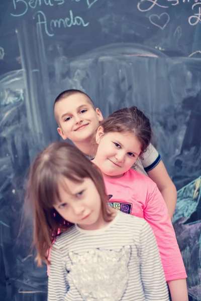 Skupina dětí stojící před tabulí — Stock fotografie
