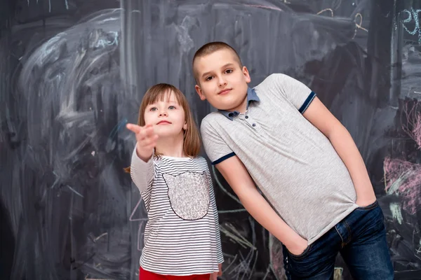 Chlapec a holčička stojí před tabulí — Stock fotografie