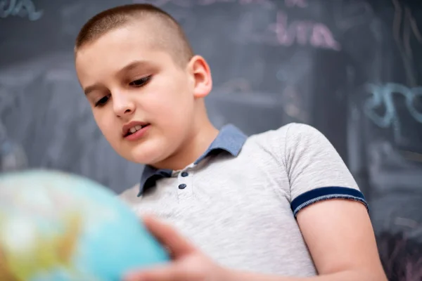 칠판 앞에서 지구를 사용하고 있는 소년 — 스톡 사진