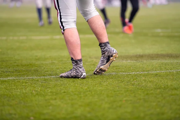 Närbild av amerikanska fotbollsspelare stretching och uppvärmning — Stockfoto