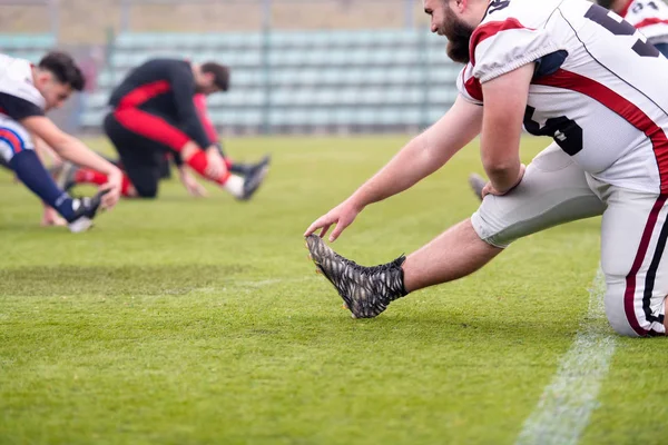 Jugadores de fútbol americano estirando y calentando —  Fotos de Stock