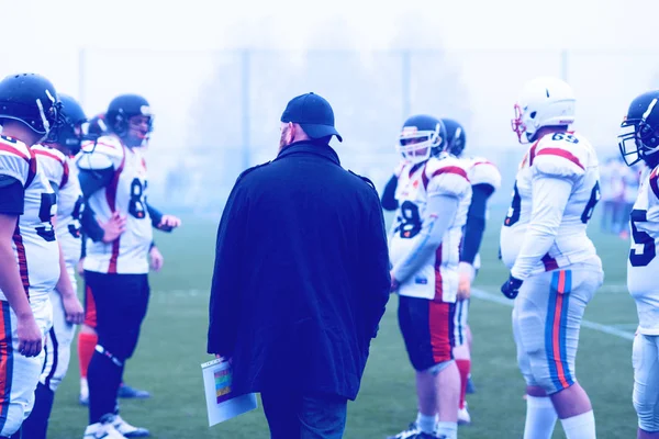 Joueurs de football américain discuter de stratégie avec l'entraîneur — Photo