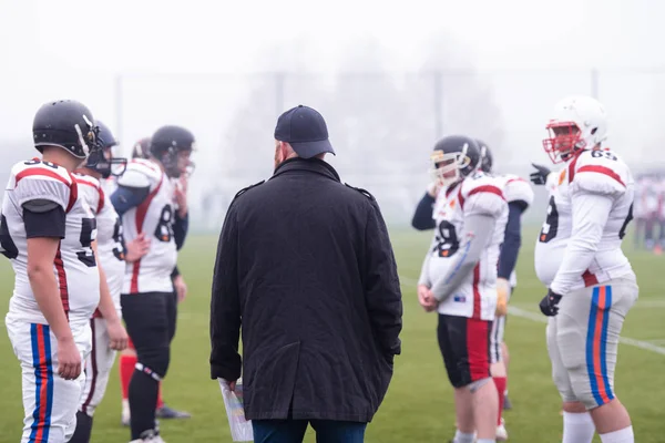 Giocatori di football americano discutendo strategia con allenatore — Foto Stock