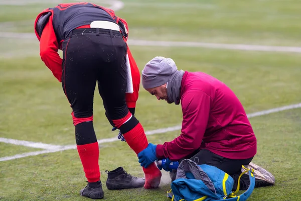 Medico sportivo che utilizza spray congelante durante il trattamento di sportm feriti — Foto Stock