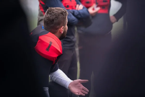 American football player discussing strategy with his team — Stock Photo, Image