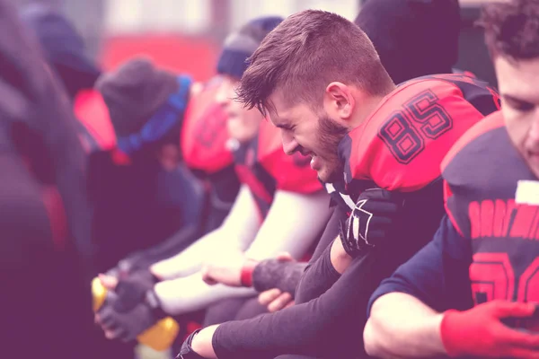 Jogador de futebol americano segurando o ombro ferido — Fotografia de Stock