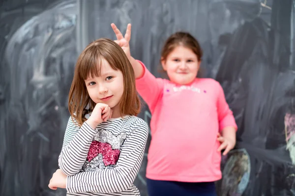 Kleine meisjes hebben plezier in de voorkant van schoolbord — Stockfoto