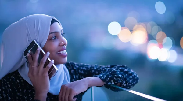 Wanita muslim muda di jalan pada malam hari menggunakan telepon — Stok Foto