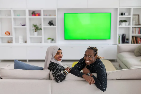 Pareja africana sentada en un sofá viendo televisión juntos —  Fotos de Stock