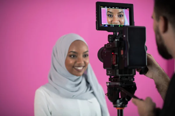 Videógrafo em estúdio rosa gravação de vídeo no profissional veio — Fotografia de Stock