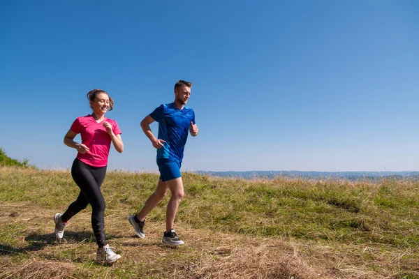 Jong paar joggen op zonnige dag in de zomer berg — Stockfoto