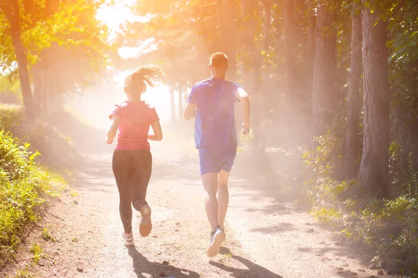 Jovem casal jogging no dia ensolarado na natureza — Fotografia de Stock