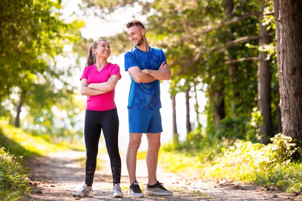 Porträtt av unga par jogga på solig dag i naturen — Stockfoto