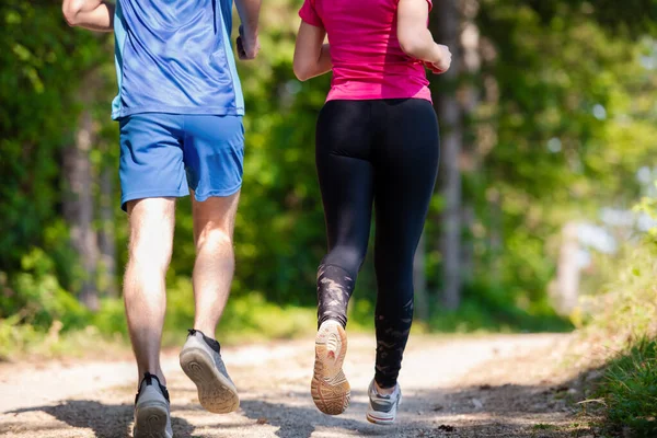 Jovem casal jogging no dia ensolarado na natureza — Fotografia de Stock