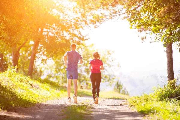 Mladý pár jogging na slunný den v přírodě — Stock fotografie