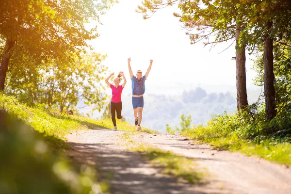 Jovem casal jogging no dia ensolarado na natureza — Fotografia de Stock