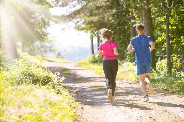 Mladý pár jogging na slunný den v přírodě — Stock fotografie