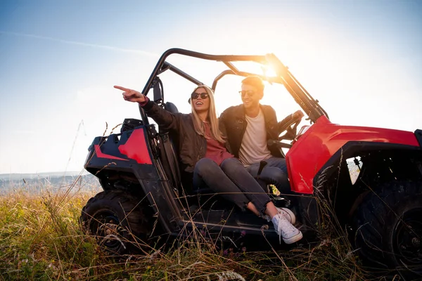 Jovem casal dirigindo um carro buggy off road — Fotografia de Stock