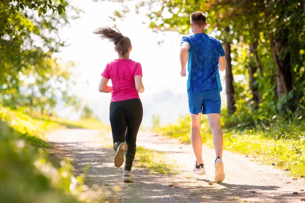 Mladý pár jogging na slunný den v přírodě — Stock fotografie