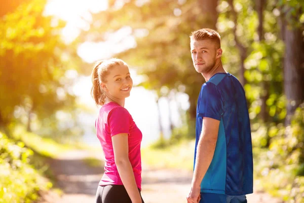 自然の中で晴れた日にジョギングをしている若いカップルの肖像画 — ストック写真