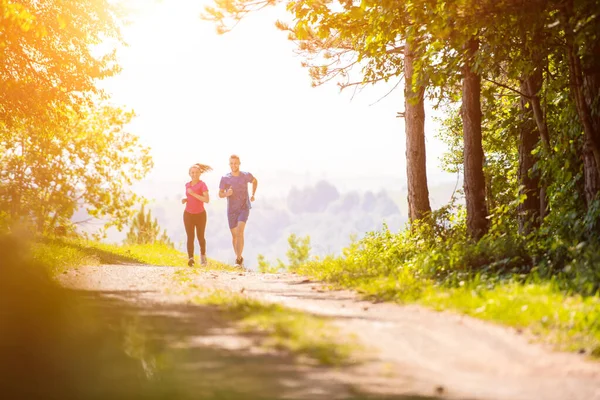 晴れた日に自然の中でジョギングをしている若いカップル — ストック写真