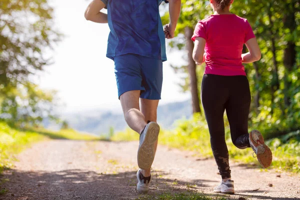 Giovane coppia che fa jogging in giornata di sole nella natura — Foto Stock