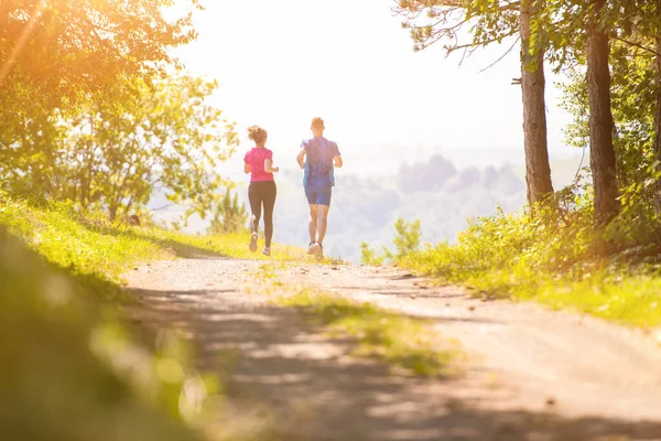 晴れた日に自然の中でジョギングをしている若いカップル — ストック写真